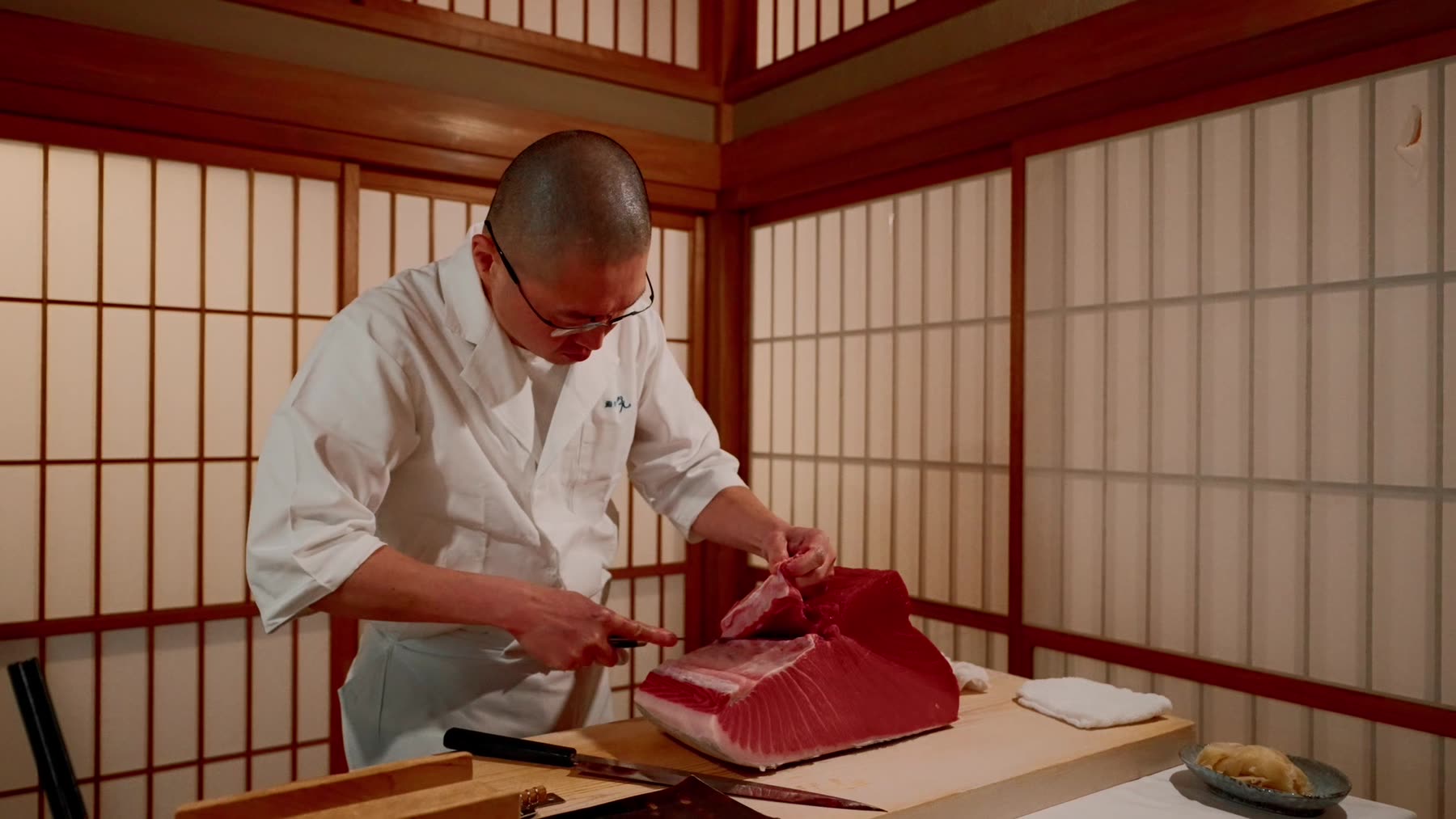 A chef breaking down a whole bluefin tuna inside the residence